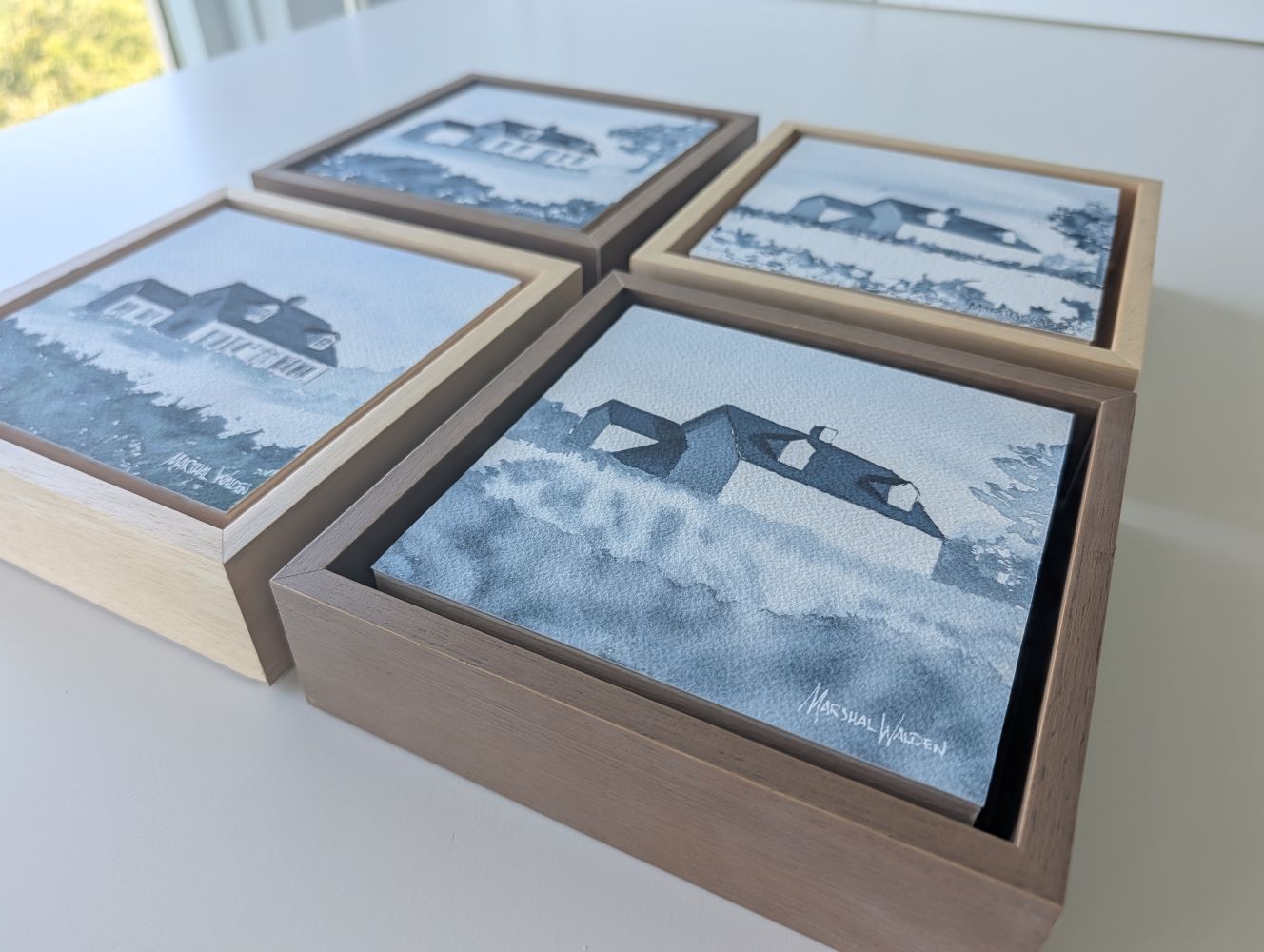 Structural watercolor studies of minimalist New England architecture, mounted as complete objects on birch cradles. Monochrome blue and grey washes capture distilled geometry under quiet, raking studio light.