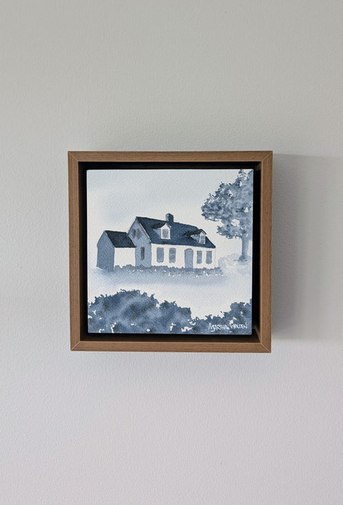 Front view of Abide, a minimalist monochrome watercolor study of a coastal home, isolated within a deep light walnut float mount frame on a neutral wall.