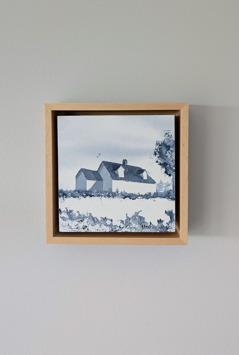 Front view of Presence, a minimalist monochrome watercolor study of a coastal home, isolated within a deep natural maple float mount frame on a neutral wall.