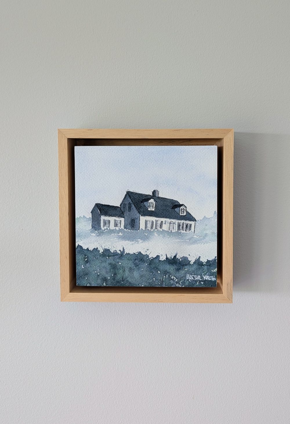 Front view of Witness, a minimalist monochrome watercolor study of a coastal home, isolated within a deep natural maple float mount frame on a neutral wall.