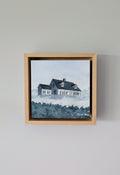 Front view of Witness, a minimalist monochrome watercolor study of a coastal home, isolated within a deep natural maple float mount frame on a neutral wall.