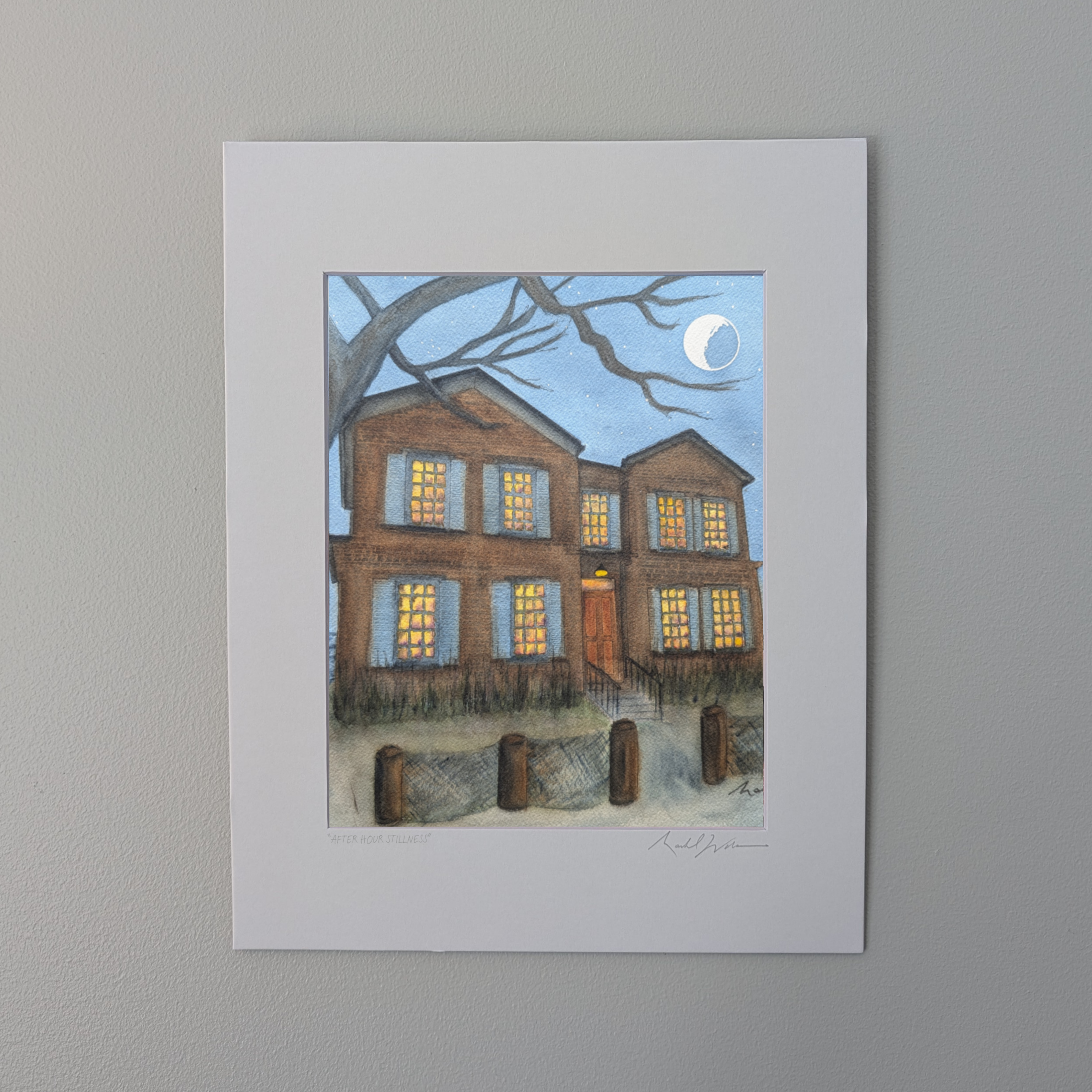 signed by PAAM member artist Marshal Walden. The artwork depicts the historic Cape Cod shingled home made famous by the TV series American Horror Story: Red Tide, located in Provincetown's West End. The scene features a bright moon and stars in a night sky with warm light glowing from the windows. The piece is presented in a white mat against a neutral beige wall.
