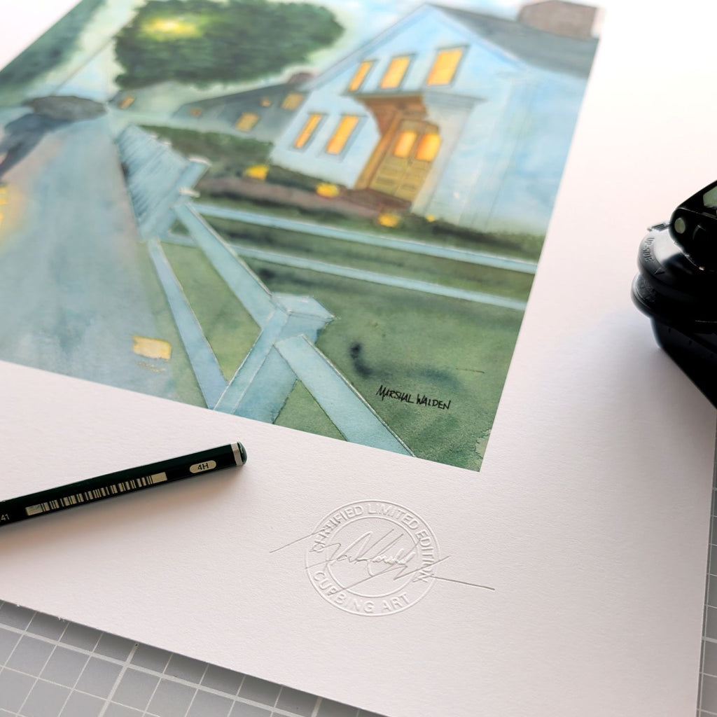 A close-up photograph showing the authentication details on the border of a limited edition fine art print of "Stroll In Rain." The focus is on the official, raised "Curbing Art" studio embossing seal pressed into the paper. Resting beside the seal are the artist's graphite pencil used for signing and numbering, and the metal hand-embossing tool. The texture of the fine art paper is clearly visible.
