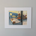 A professional white-matted watercolor print by Marshal Walden depicting Liz's Café Anybody's Bar in Provincetown. The scene features a deep indigo summer evening sky outside, contrasting with the warm, glowing globe lights of the interior. Visible through the windows are a boat-shaped bar, a sailboat ship-style wheel, and a vacant table for two.
