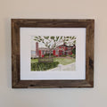 A framed original watercolor painting of The Red Inn in Provincetown, housed in a natural wood frame with a double white mat.