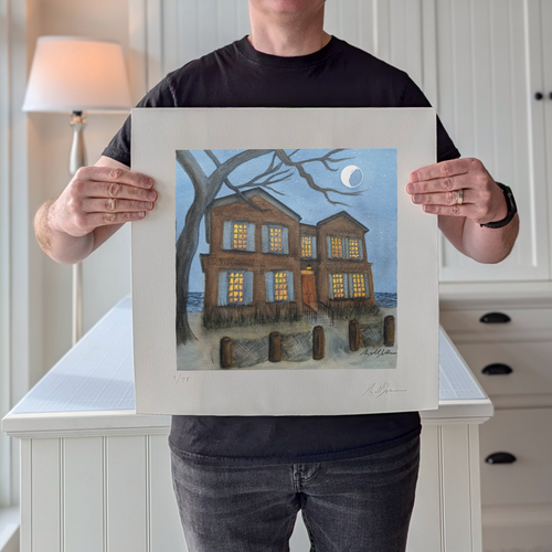 A photograph of PAAM member artist Marshal Walden holding the 16x16 limited edition fine art print "After Hour Stillness" in a home studio setting. The image demonstrates the print's scale and highlights the detailed watercolor texture and extra-wide crisp white borders, which allow for versatile framing either without a mat for a modern look or matted to a standard 10x10 opening for a traditional presentation. His pencil signature and edition numbering are visible on the bottom border.
