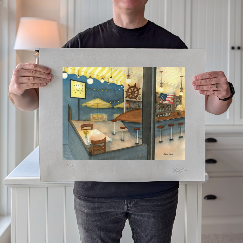 A photograph of PAAM member artist Marshal Walden holding the 16x20 inch limited edition fine art print "Anybody's Bar". The image demonstrates the print's scale and highlights the detailed watercolor artwork and the extra-wide crisp white borders, which are designed for versatile framing, either without a mat for a modern look or matted to a standard 11x14 opening.
