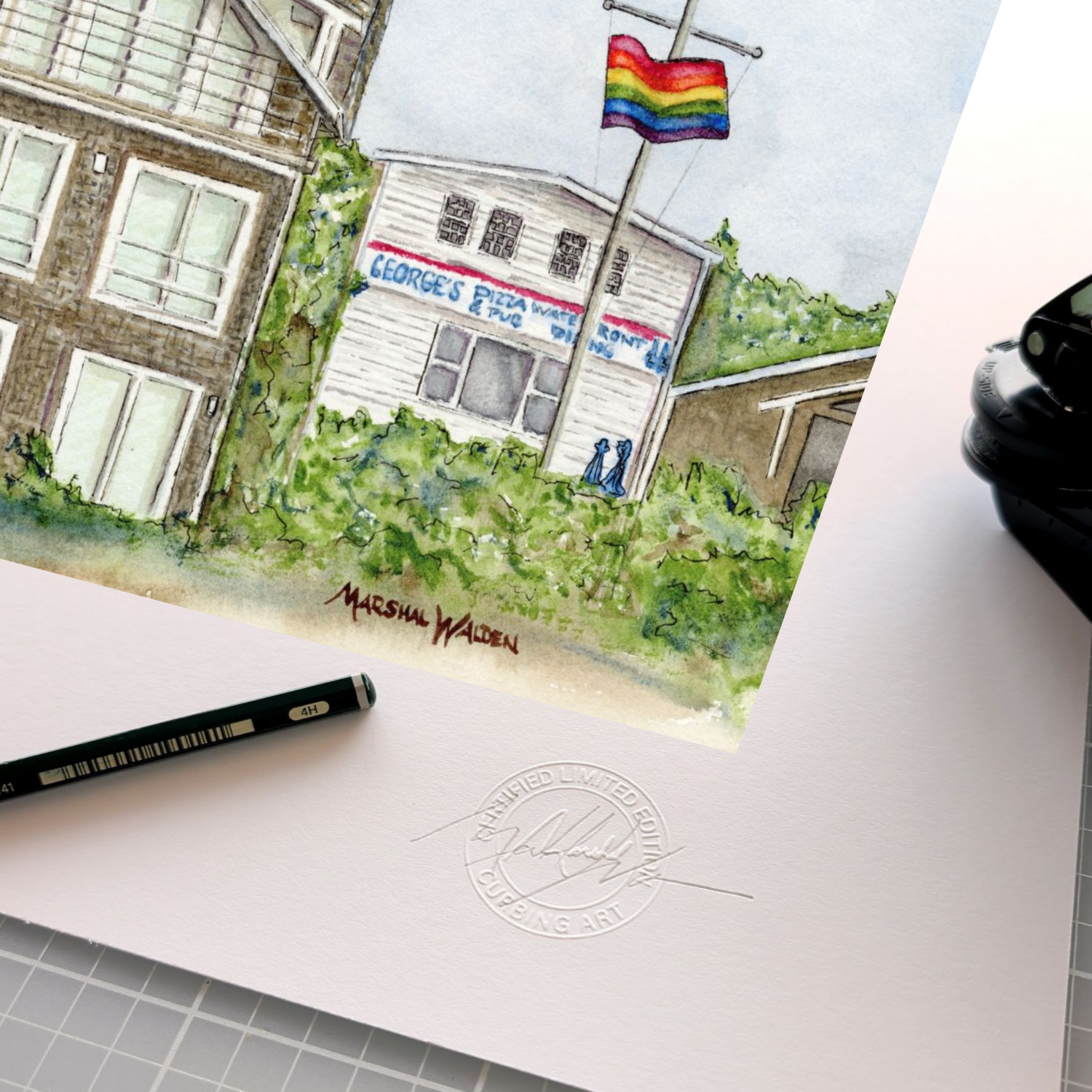 A detailed close-up photograph showing the authentication tools resting on the wide white border of the limited edition fine art print "Monumental Pride." The focus is on the official, raised circular "Curbing Art" studio embossing seal pressed into the surface of the textured fine art paper. Lying next to the seal are the artist's graphite pencil used for signing and numbering, and the metal hand-embossing tool used to create the seal. A portion of the artwork showing the Provincetown skyline is visible at