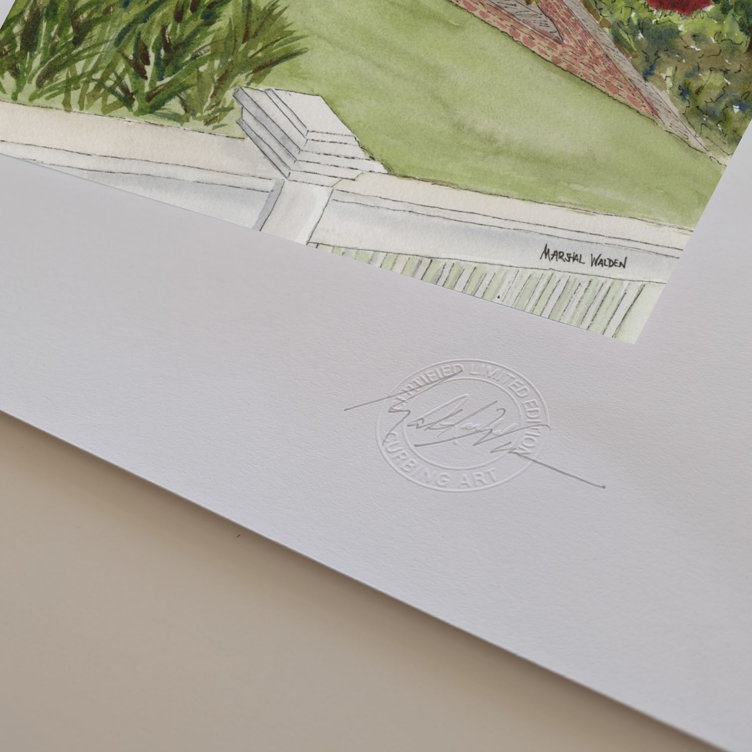 A macro photograph showing the lower corner details of the limited edition fine art print "Red Inn." The focus is on PAAM member artist Marshal Walden's signature written in graphite pencil next to the raised, circular official "Curbing Art" studio embossing seal pressed into the surface. The lighting and close perspective emphasize the deep texture, tooth, and substantial thickness of the heavy archival paper stock edges.

