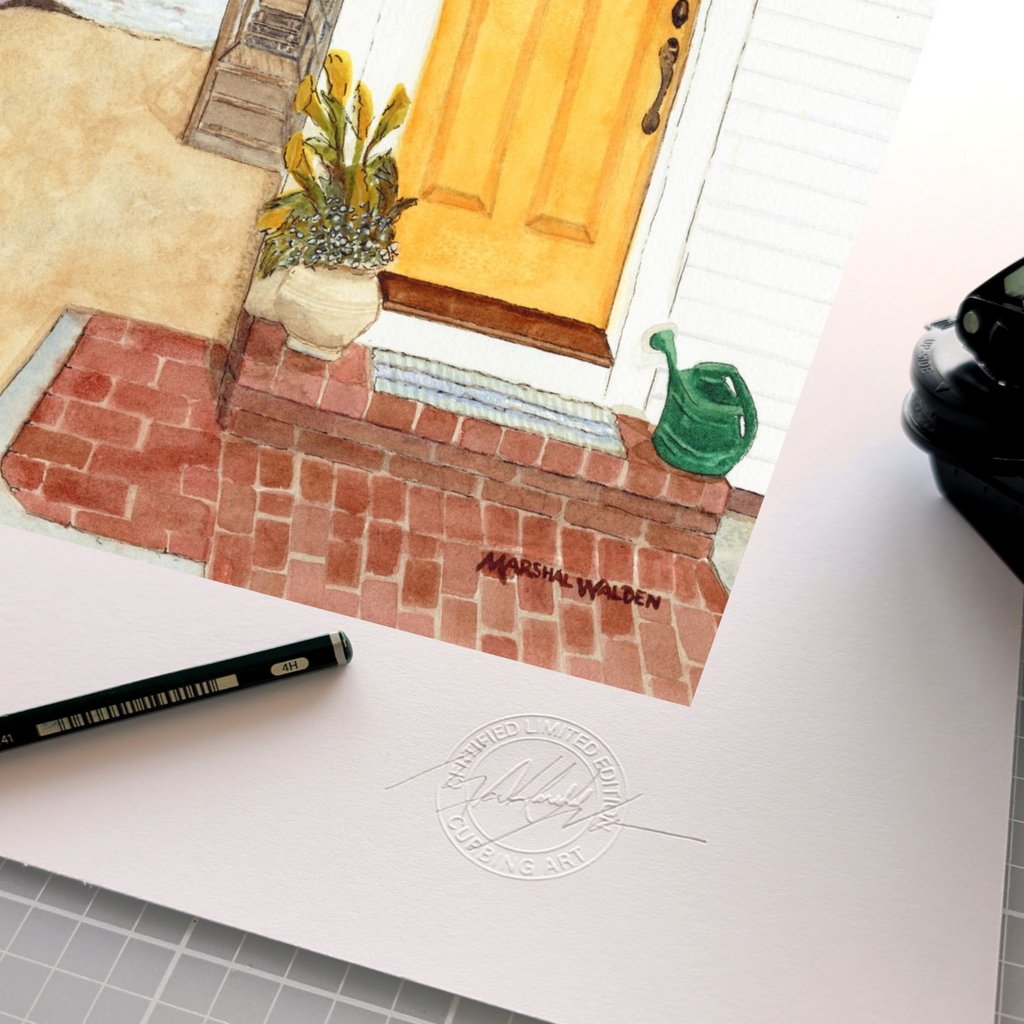 A detailed close-up photograph showing the authentication tools resting on the wide white border of the limited edition fine art print "The Turn - Yellow Door." The focus is on the official, raised circular "Curbing Art" studio embossing seal pressed into the surface of the textured fine art paper. Lying next to the seal are the artist's graphite pencil used for signing and numbering, and the metal hand-embossing tool used to create the seal. A small portion of the artwork is visible at the edge.
